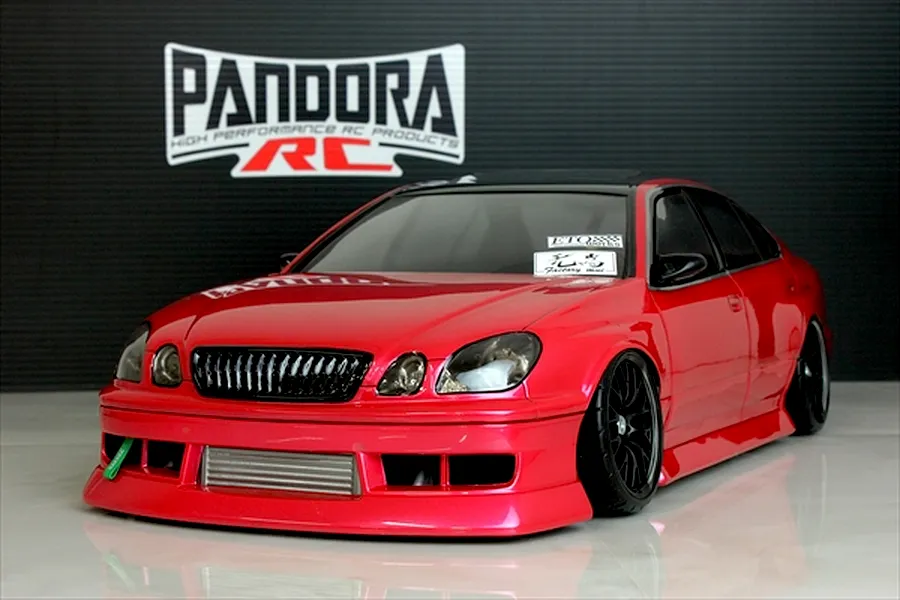 Pandora RC Toyota Aristo JZS161 RC drift car body shell painted red on display in front of a branded backdrop