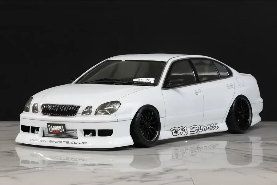 White Toyota Aristo JZS161 RC drift car body shell with BN Sports styling on a reflective surface.