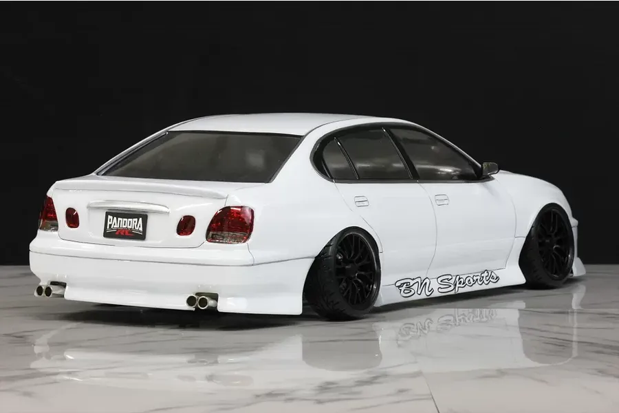 Rear-three-quarter view of a white Pandora RC Toyota Aristo JZS161 drift body shell mounted on an RC chassis with BN Sports decals.