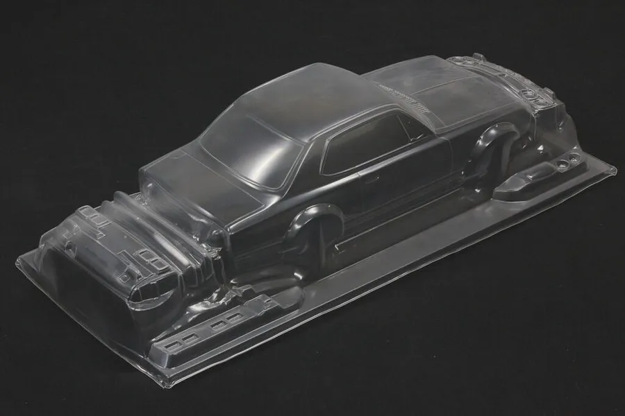 Unpainted clear polycarbonate RC car body shell for a KPGC10 Skyline HT 2000GT-R on a dark surface.