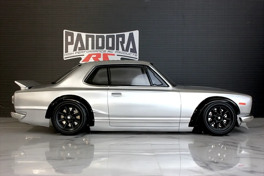 Side profile of a silver Pandora RC KPGC10 Skyline GT-R body shell mounted on an RC chassis with black wheels.