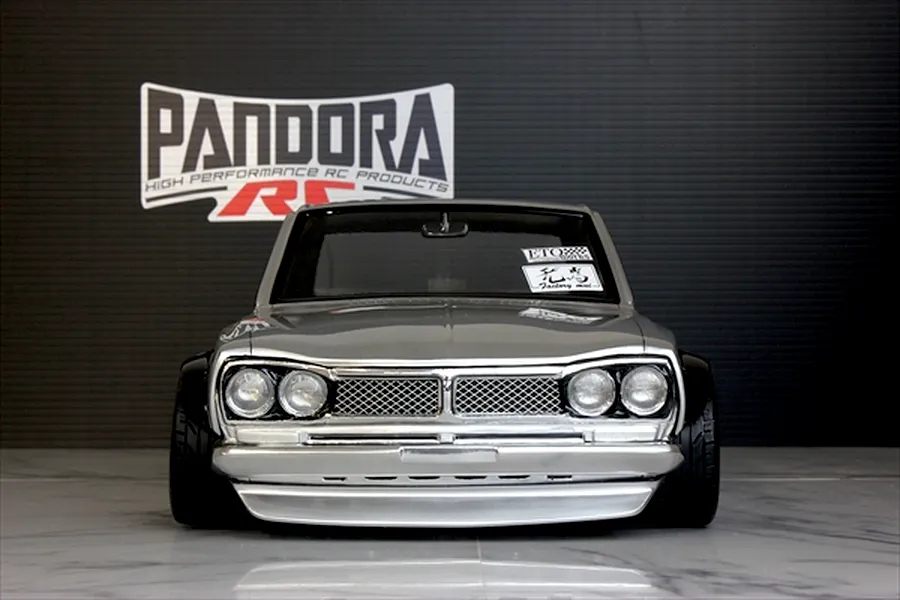 Front view of a silver Pandora RC KPGC10 Skyline GT-R body shell featuring a chrome grille, headlights, and wide black fender flares.