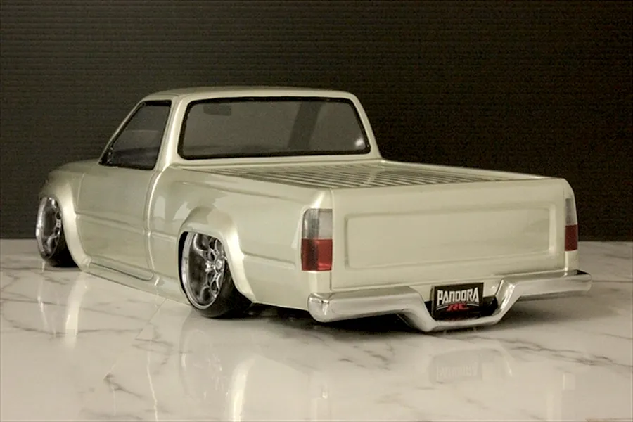 Rear three-quarter view of a custom silver RC drift truck body shell on a marble surface.