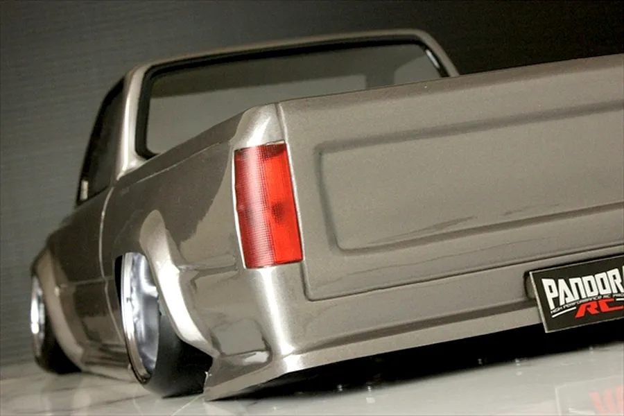 Rear quarter angle of the painted Pandora RC Toyota Hilux RN80 body shell showing the tailgate, taillight, and stance.