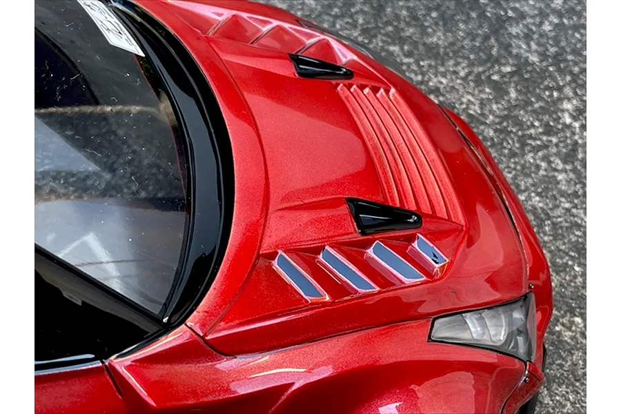 Close-up of the red metallic vented bonnet and windshield of a painted RC body shell.
