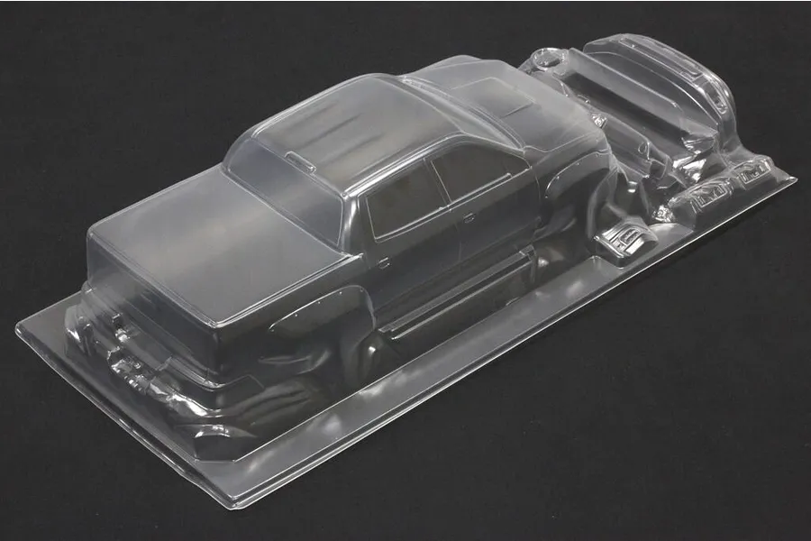 Unpainted clear polycarbonate RC truck body shell on a dark background.
