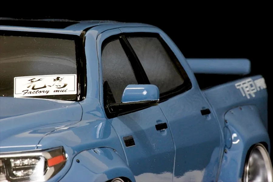 Close-up of the blue Toyota Tundra RC body shell side profile showing the door, mirror, window decal, and fender flare.