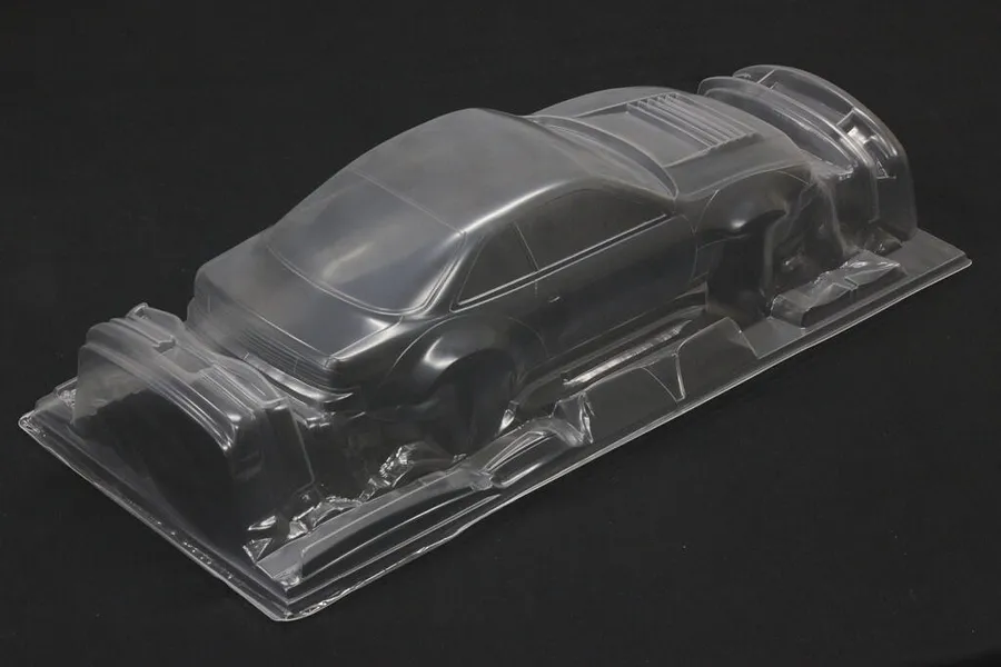 Unpainted clear polycarbonate RC car body shell for a Nissan Silvia S14 on a black background.