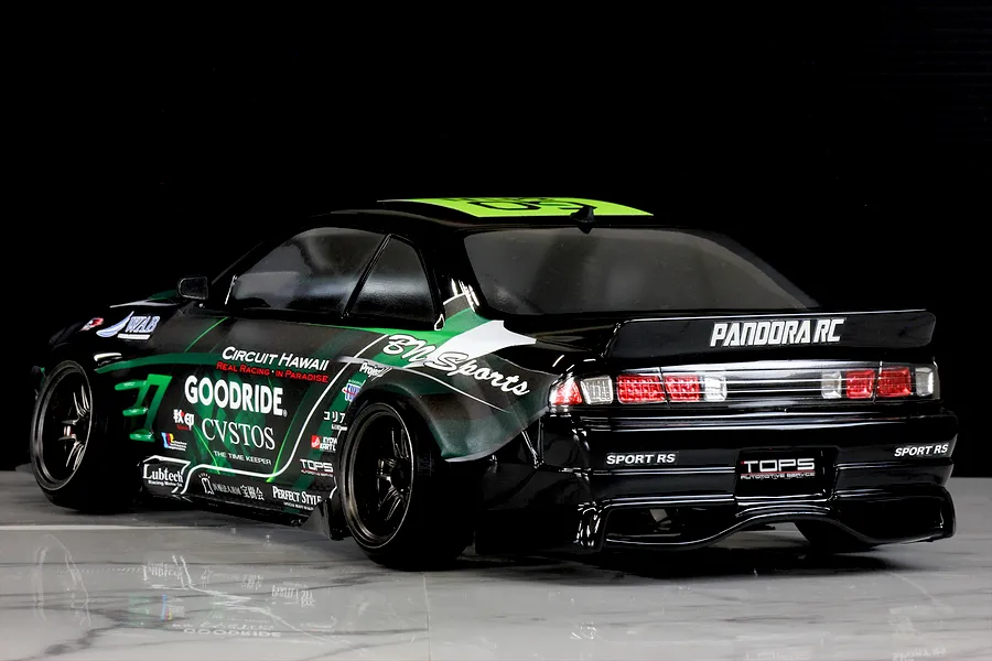 Rear three-quarter view of a Pandora RC S14 Silvia RC drift car featuring a black body with green and white sponsor decals.