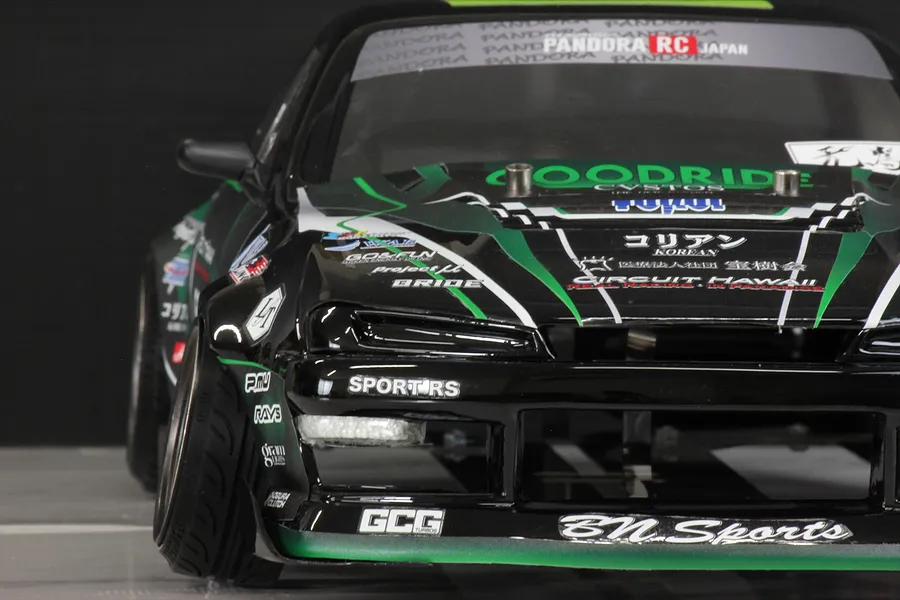 Close-up front angle of a black and green Pandora RC S14 Silvia RC drift car body featuring various sponsor decals.