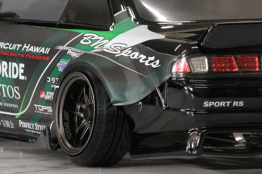 Close-up of the rear quarter, wheel, and taillight of a black Pandora RC S14 Silvia RC drift car body with BN Sports livery.