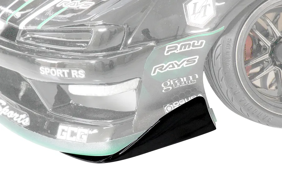 Close-up of the front corner of a Pandora RC S14 Silvia RC drift car body with sponsor decals and a black front bumper canard.