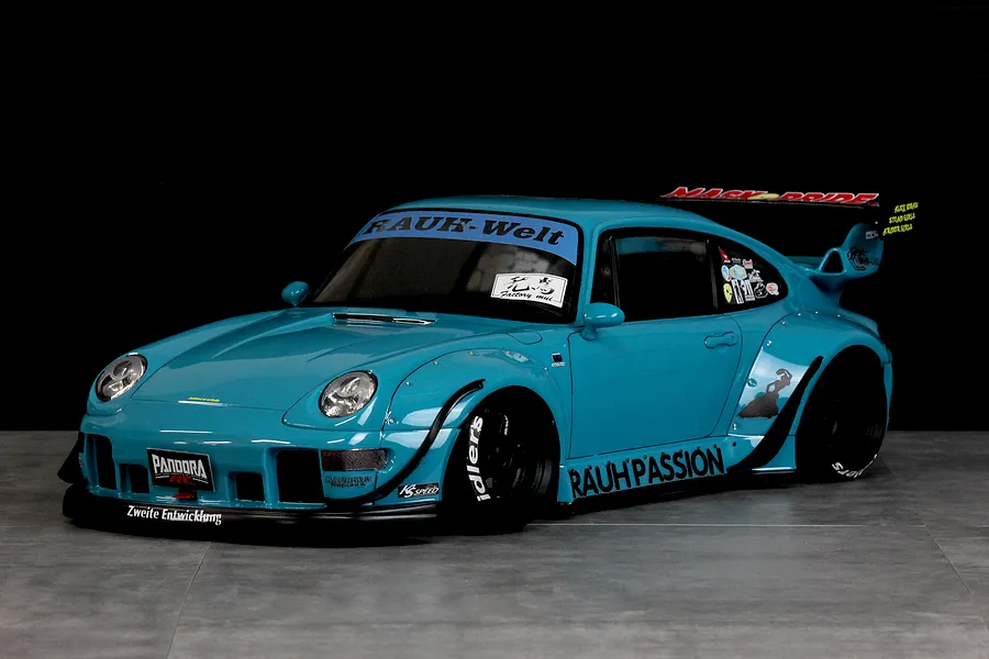 A painted Pandora RC RWB 993 Type body shell in light blue with wide fenders, black wheels, and sponsor decals.