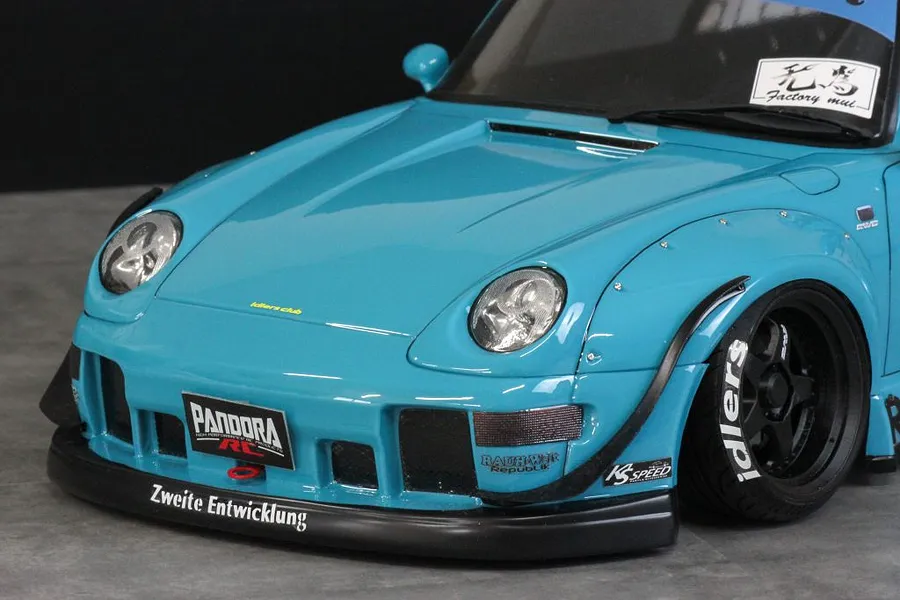 Close-up of the front section of a bright blue RWB Porsche RC drift car body shell with wide fenders and decals.