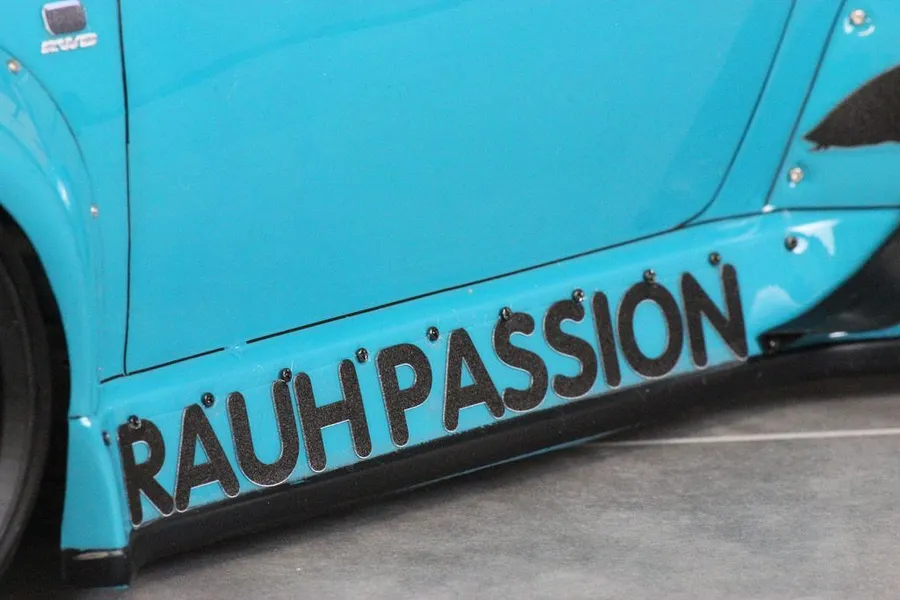 Close-up of the side skirt of a bright blue Pandora RC RWB 993 body shell featuring the text RAUH-PASSION.