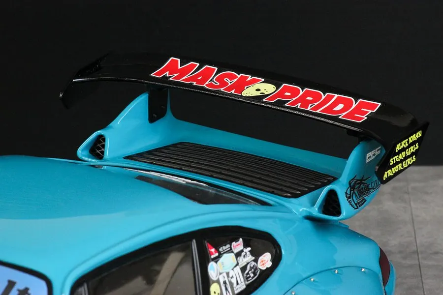 Close-up of the rear wing and spoiler on a light blue RWB 993 RC body shell with MASK PRIDE decals.