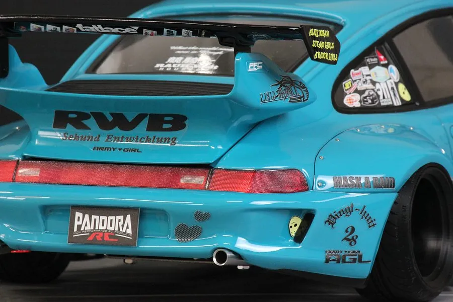 Close-up rear view of a light blue RWB 993 RC body shell featuring a large wing, decals, and Pandora RC license plate.