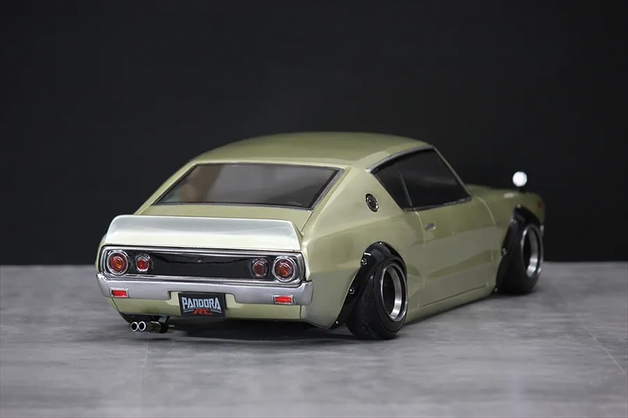 Rear three-quarter view of a gold Pandora RC KPGC110 Skyline 2000GT-R drift body shell mounted on a chassis.