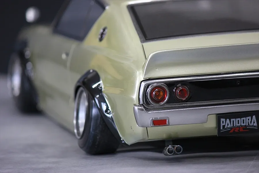 Close-up rear angle of a light green Pandora RC KPGC110 Skyline 2000GT-R drift car body shell showing wheels, tail lights, and exhaust.