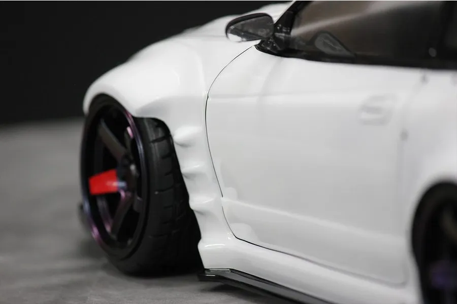 Close-up of the front fender and wheel on a white RC drift car body.