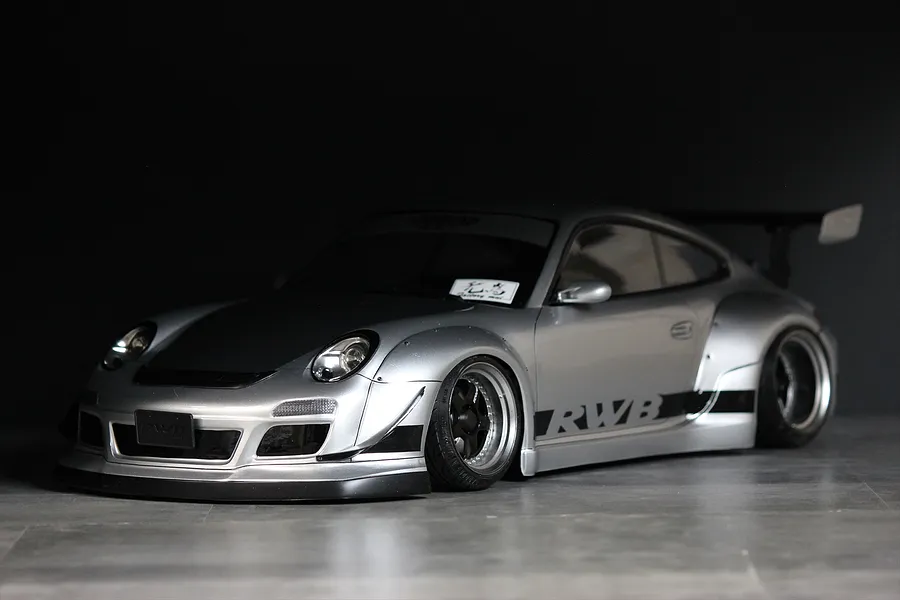 Silver Pandora RC RWB 997 body shell painted and fitted onto an RC drift car chassis, showcasing wide fenders and rear wing.