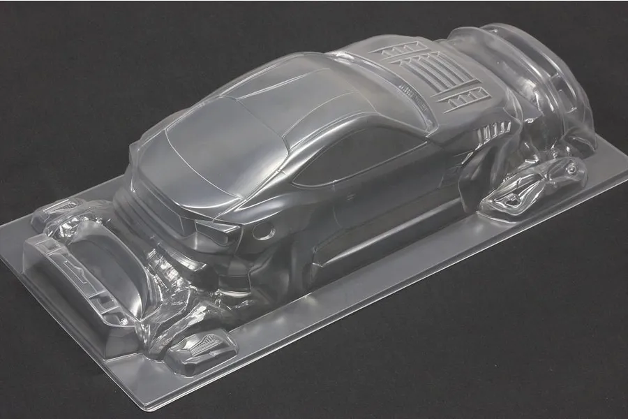 Unpainted clear polycarbonate RC drift car body shell viewed from the rear three-quarter angle against a dark background.