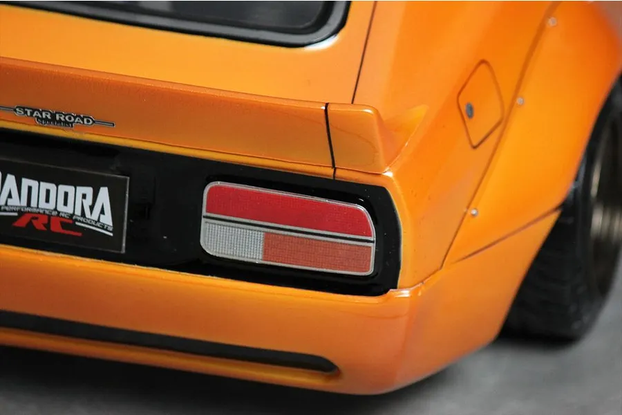 Close-up of the rear corner of an orange Pandora RC S30 Fairlady Z body shell featuring a Star Road badge and detailed tail light.
