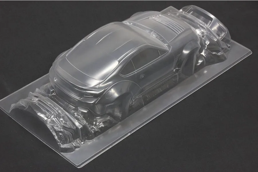 Unpainted clear polycarbonate RC car body shell on a dark background showing rear three-quarter view.