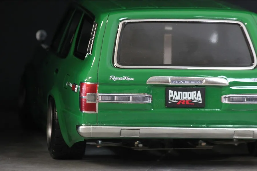 Close-up rear view of a green RC car body shell showing tail lights, chrome bumper, and Pandora RC license plate.
