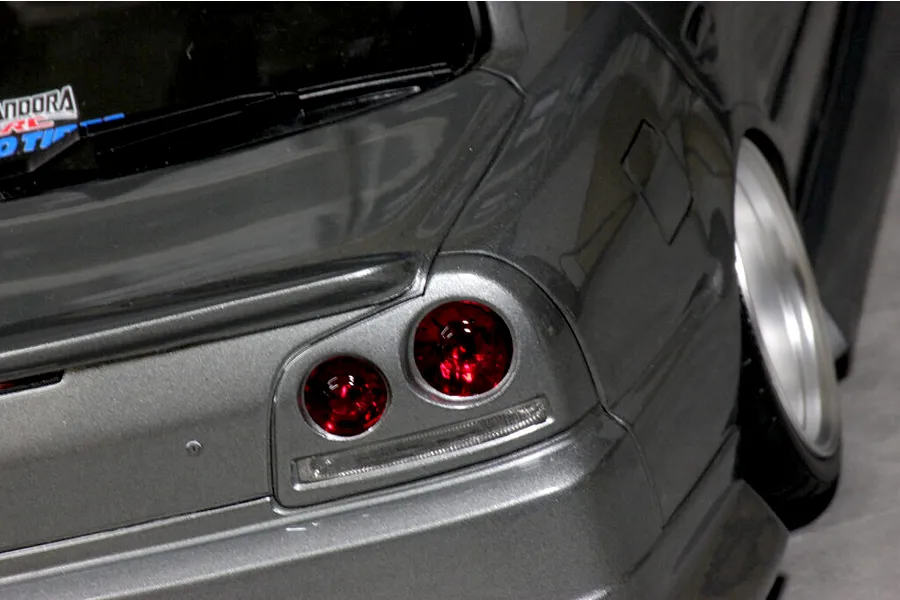 Close-up detail shot of a grey RC car body shell showing the rear taillight and wheel camber.