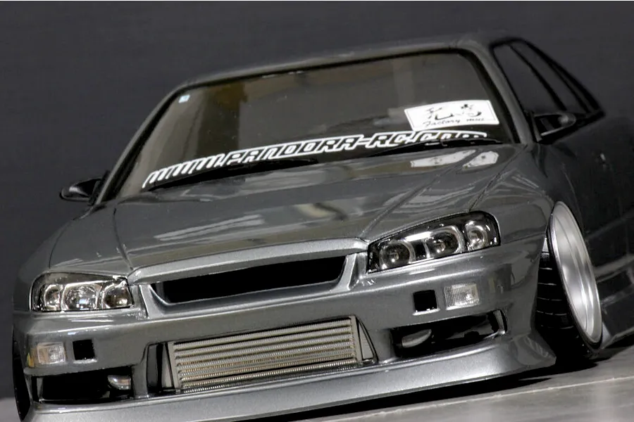 Low angle front view of a grey ER34 Skyline RC drift car body with low stance, intercooler, and windshield decals.