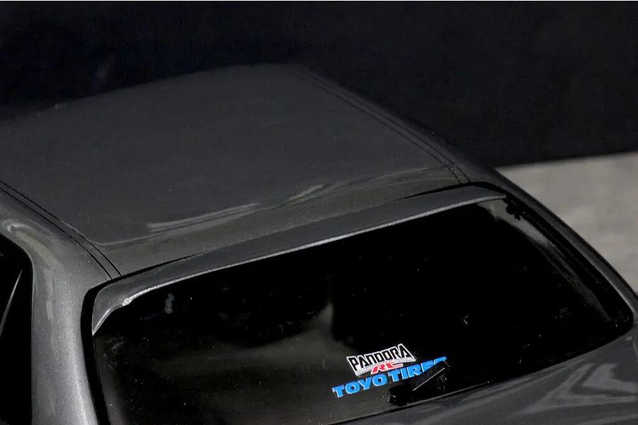 Close-up of the grey RC car body roof, rear window, and roof spoiler with Pandora RC and Toyo Tires decals.
