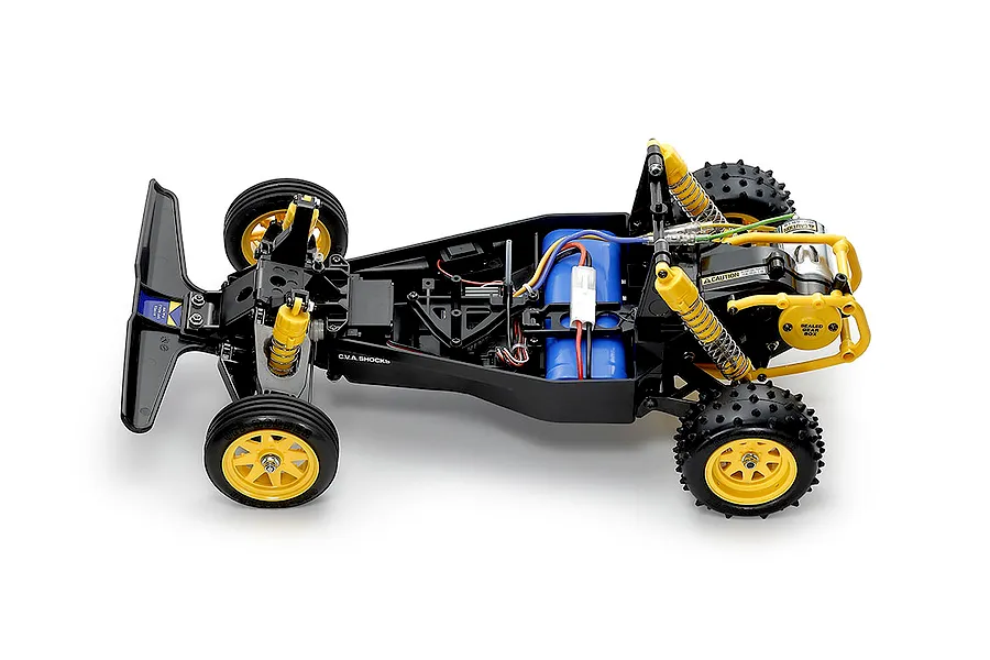 Top-down studio view of the chassis for the Tamiya The Falcon 2026 electric RC buggy showing internal components, suspension, and yellow wheels.