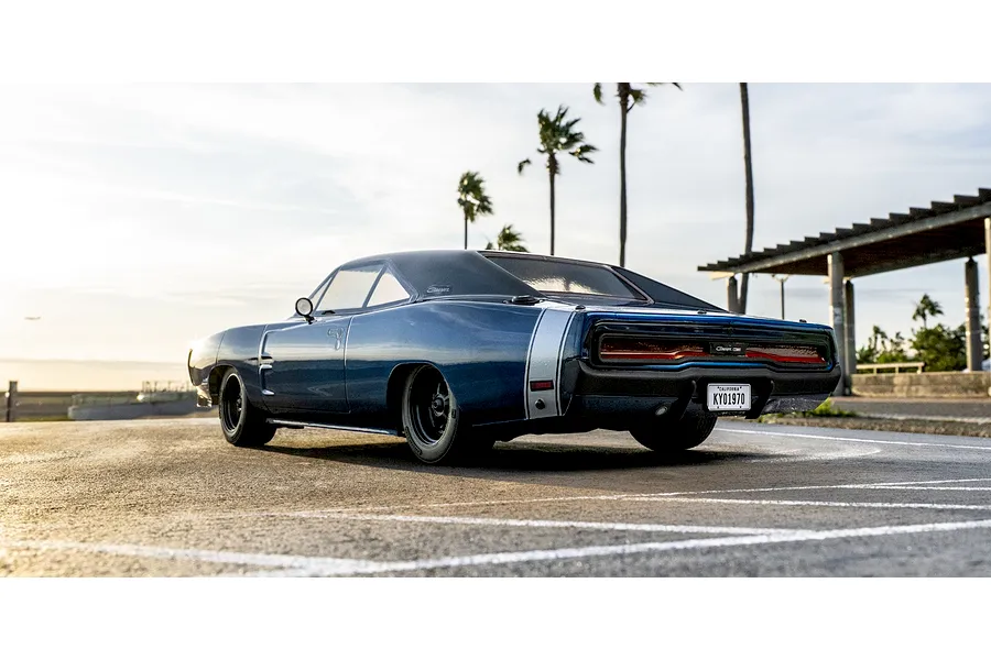 Kyosho Fazer MK2 1970 Dodge Charger RC car parked outdoors on a paved lot with palm trees in the background.