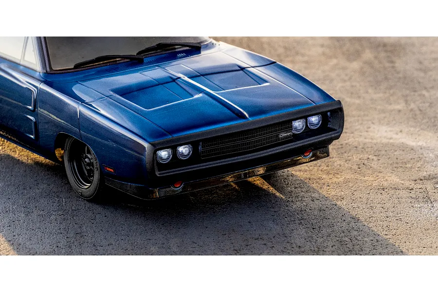 Close-up lifestyle shot of the front section of the blue Kyosho 1970 Dodge Charger RC car on asphalt.