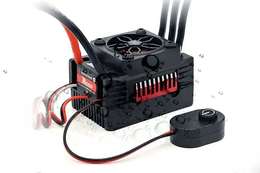 Surpass Rocket 90A Brushless ESC with built-in fan, attached wires, and external switch against a white background with water splashes.