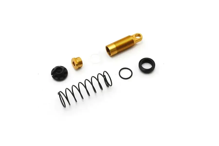 Kyosho rear adjustable shock absorber parts laid out flat on a clean white background, including a gold shock body, spring, and hardware.
