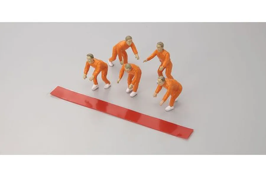 Five small plastic figurine figures in orange jumpsuits with a red adhesive strip on a grey background.