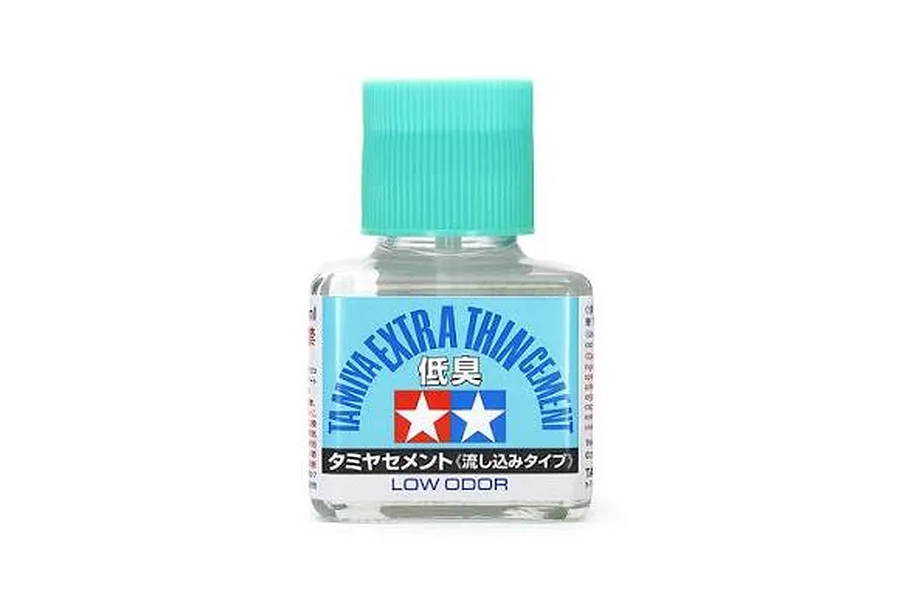 Tamiya Low Odour Extra Thin Cement bottle with a turquoise cap and blue and white label against a white background.