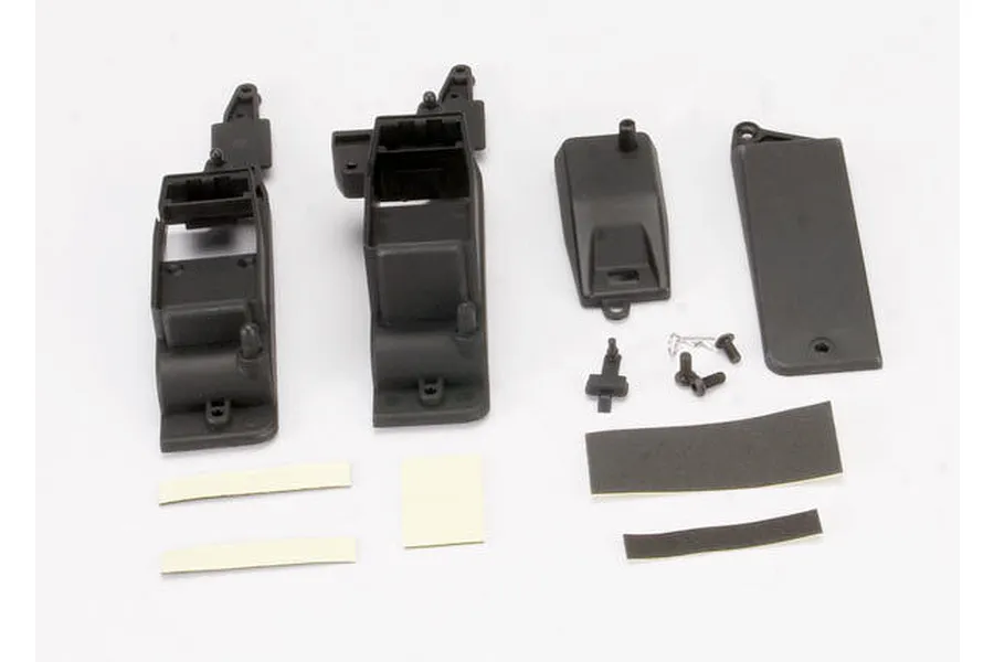 Traxxas receiver box set components including black plastic housing parts, cover, foam tape strips, screws, and hardware laid out on a white background.