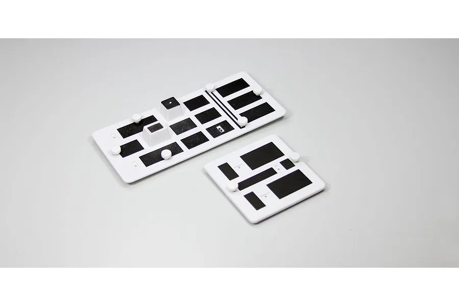 Kyosho hatch set featuring two white panels with black foam inserts and small white knobs on a light grey background.