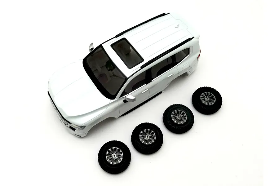 Kyosho Mini-Z Toyota Land Cruiser 300 white painted body shell viewed from above alongside four matching tires and wheels on a plain white background.