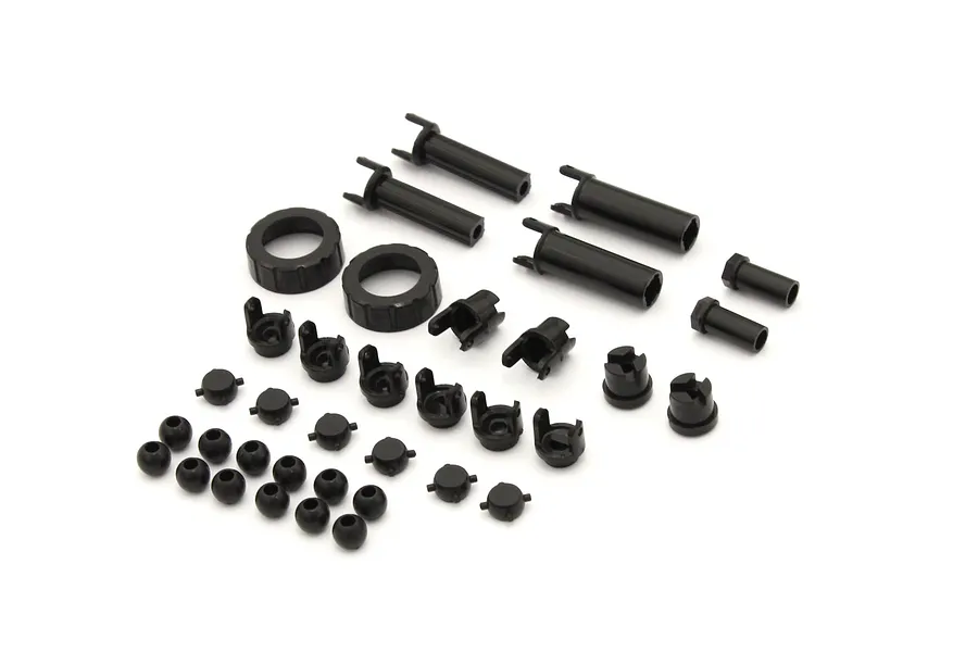 Kyosho axle parts set including black plastic drive shafts, universal joints, ball ends, and collars arranged on a white background.
