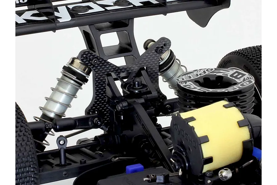 Kyosho carbon fibre rear shock tower installed on the rear of an RC buggy chassis, showing suspension and shock absorbers.