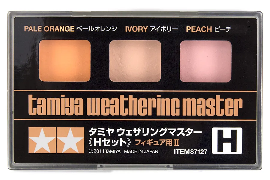 Tamiya Weathering Master Set H in a clear plastic case, featuring three powder pans in Pale Orange, Ivory, and Peach for figure detailing.