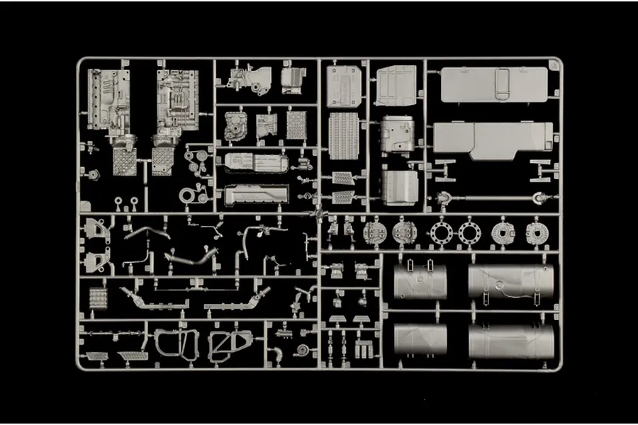 Grey plastic model parts sprue containing truck engine and chassis components on a black background.