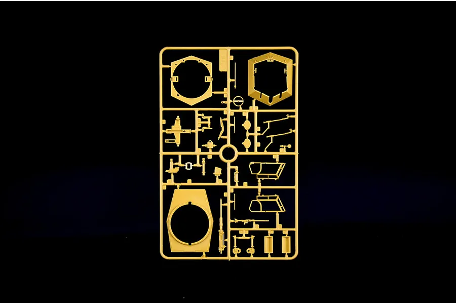 Tan plastic model kit sprue containing various parts and turret components on a black background.