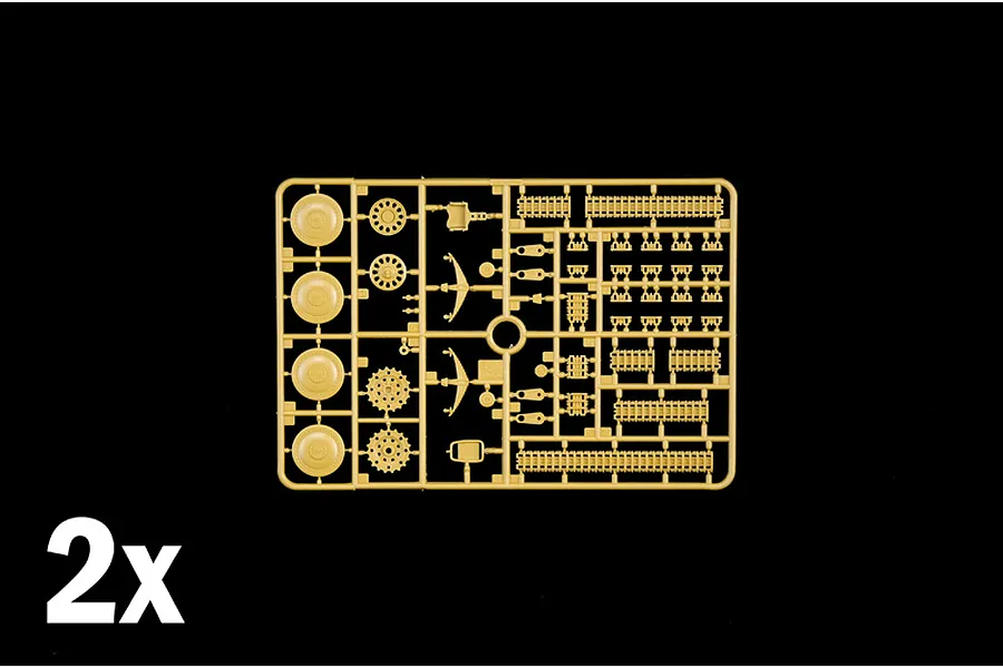 Tan plastic model sprue featuring wheels, track links, and small mechanical components with a 2x indicator.