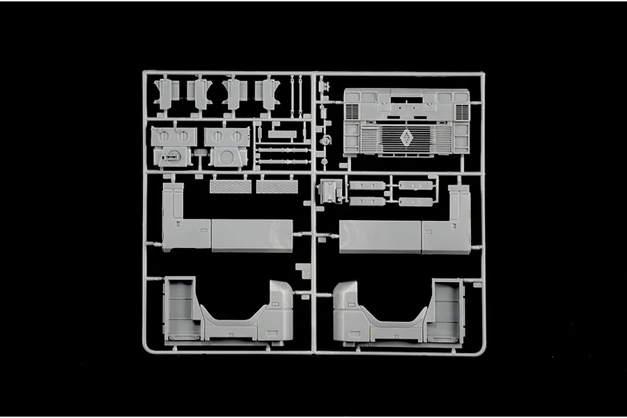 Grey plastic model kit parts sprue featuring truck parts and chassis components against a black background.