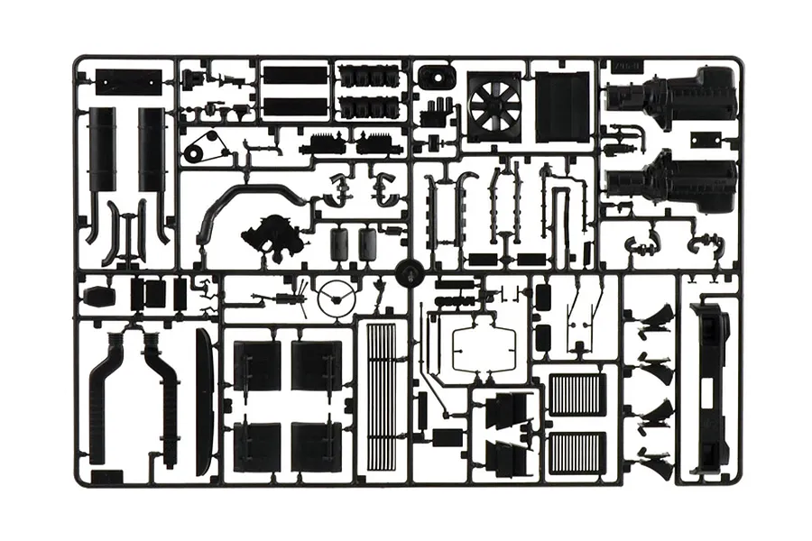 Black plastic model kit sprue containing various truck parts such as engine components and chassis elements against a white background.